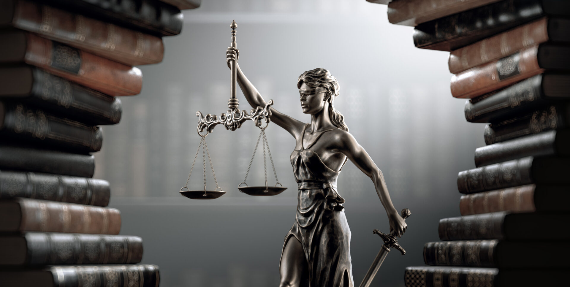 Lady Justice statue between stacks of books.